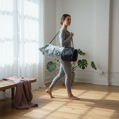 Woman carrying white and black Om yoga mat bag through a softly lit wellness room with natural wood flooring and indoor plants. — for Carpe Diem Dream