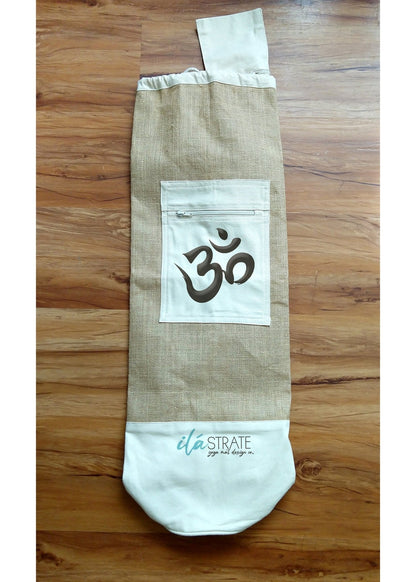 White cotton jute Om yoga mat bag displayed flat on natural wood flooring. — for Carpe Diem Dream