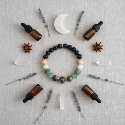 A natural stone and lava bead diffuser bracelet with a round orbital focal bead arranged in a symmetrical flat lay with essential oil bottles, lavender sprigs, quartz crystals, and a crescent moon on textured linen. — for Carpe Diem Dream