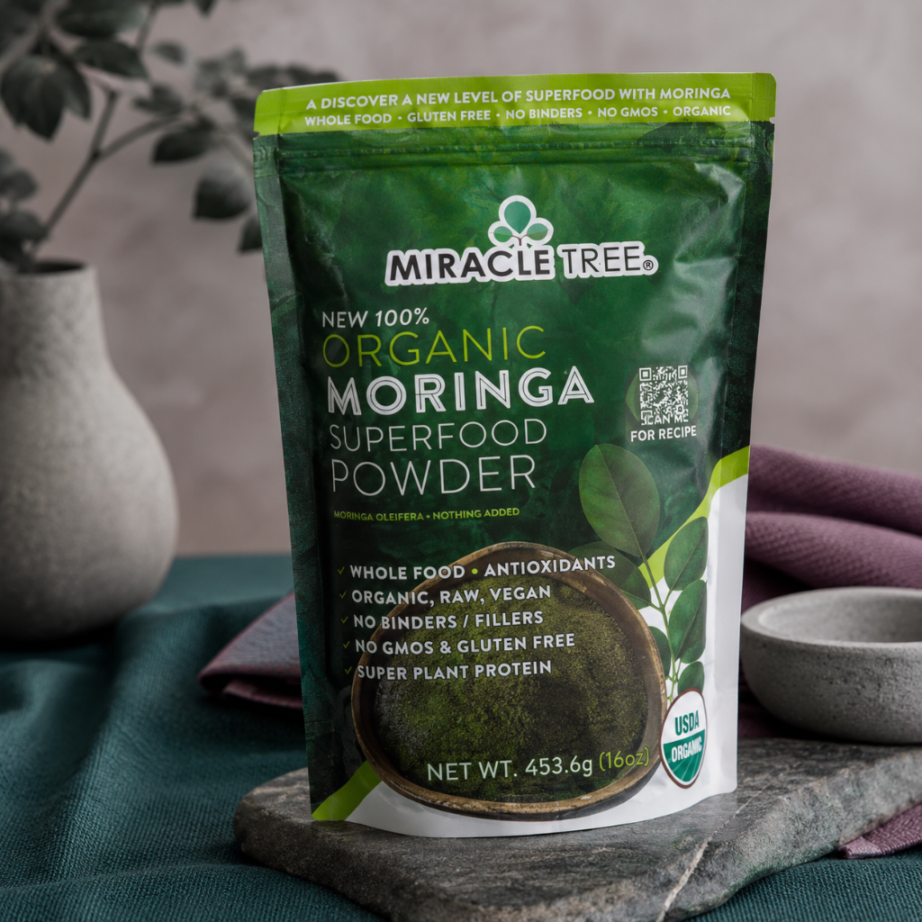 Organic Moringa Superfood Powder 16oz pouch shown close-up with textured packaging, front label detail, dark teal linen, mauve textile, and stone styling. — for Carpe Diem Dream
