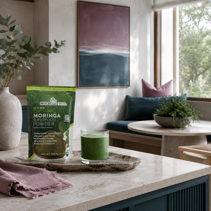 Organic Moringa Superfood Powder 16oz pouch styled in a serene wellness kitchen with green smoothie, mauve linen, dark teal accents, and calm room details. — for Carpe Diem Dream