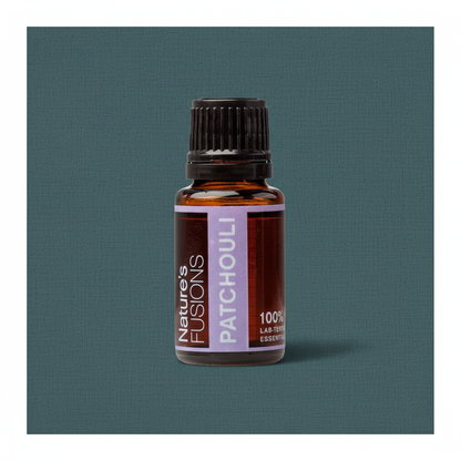 Close-up of amber glass bottle of Patchouli Essential Oil with black ribbed cap on muted teal textured background in soft directional light. — for Carpe Diem Dream
