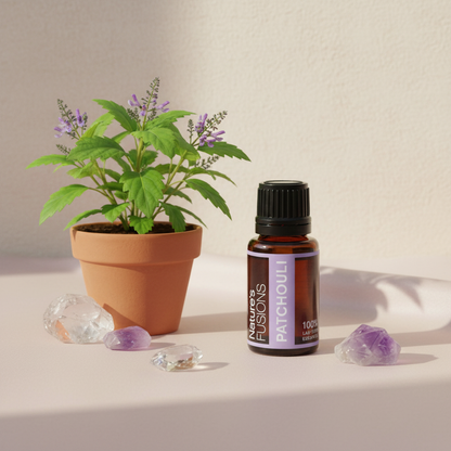 Amber glass bottle of Patchouli Essential Oil styled beside fresh green patchouli leaves and polished crystal stones on a neutral fabric surface in soft natural light. — for Carpe Diem Dream
