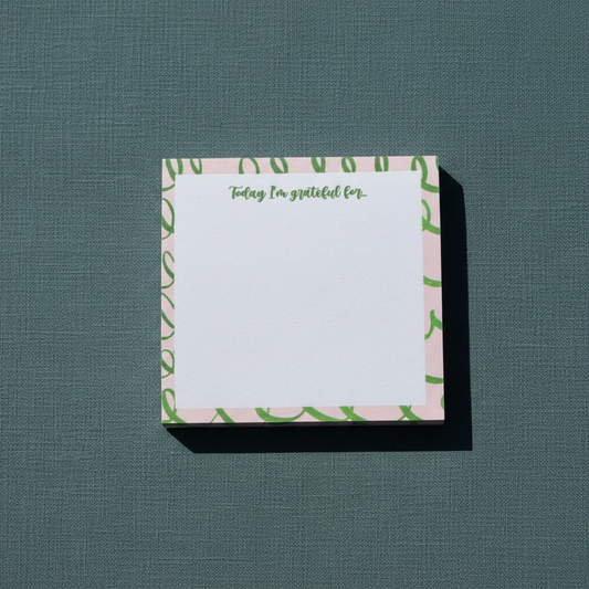 Square pink and green gratitude sticky note pad with “Today I’m grateful for” text displayed on a textured muted teal surface. — for Carpe Diem Dream