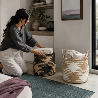 Black and white plaid woven storage baskets shown in use as folded blankets are placed inside for calm bedroom storage. — for Carpe Diem Dream