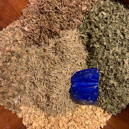 Organic ingredients and Lapis Lazuli crystal used in Psychic Abili-Tea – Organic Crystal Infused, displayed in a wooden blending bowl showing the herbal components and crystal energy source behind the tea blend. — for Carpe Diem Dream
