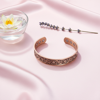 A pure copper floral cuff bracelet arranged beside a glass bowl with a lotus flower and lavender sprig on soft pink fabric, creating a calm ritual-inspired setting. — for Carpe Diem Dream
