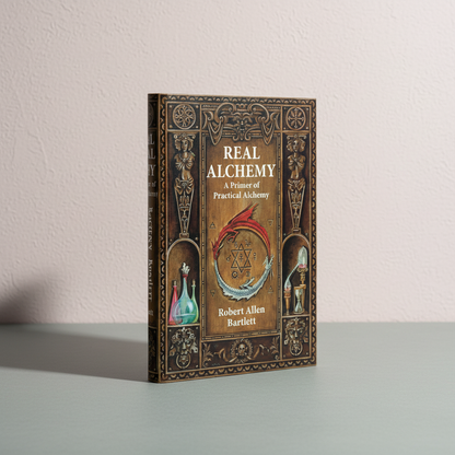 The paperback book Real Alchemy displayed upright on a soft neutral surface with clean editorial lighting and a textured wall backdrop. — for Carpe Diem Dream