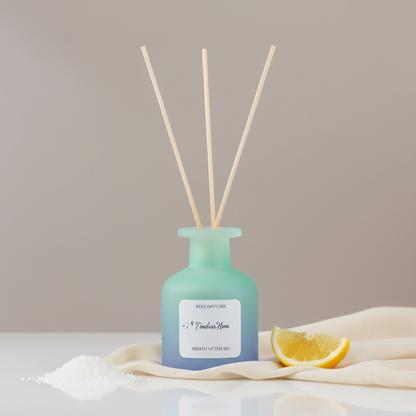 A frosted glass reed diffuser in a soft blue gradient bottle with natural reed sticks styled with a lemon slice, sea salt, and soft fabric on a neutral surface in soft natural light. — for Carpe Diem Dream