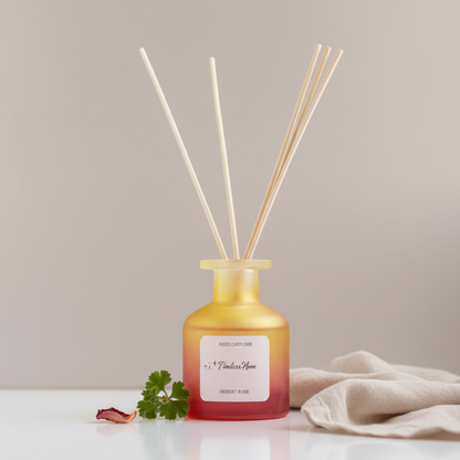 A frosted glass reed diffuser in a warm yellow to coral gradient bottle with natural reed sticks styled with soft fabric and minimal botanical accents on a clean neutral surface. — for Carpe Diem Dream