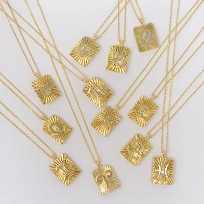 Reversible gold zodiac necklaces with constellation pendant, showing both polished and engraved sides on white background for Carpe Diem Dream