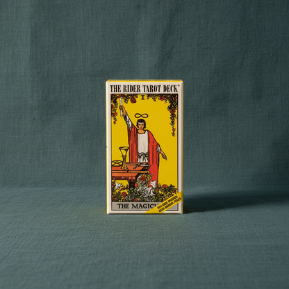 Rider Waite tarot card deck box displayed upright on a deep teal linen background with soft directional lighting. — for Carpe Diem Dream