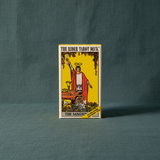 Rider Waite tarot card deck box displayed upright on a deep teal linen background with soft directional lighting. — for Carpe Diem Dream