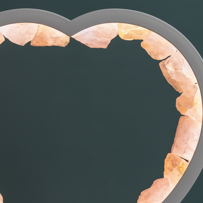A close-up view of rose quartz crystal points lining a curved heart frame against a muted teal backdrop in soft natural light. — for Carpe Diem Dream