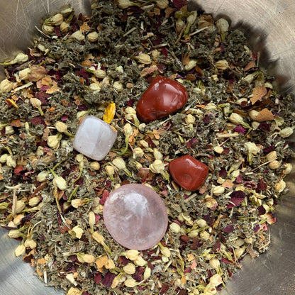 Sacred Body Temple Tea – Organic Crystal Infused herbal blend featuring rose petals, hibiscus, jasmine flowers, red raspberry, eleuthero root, orange zest, Red Jasper, and Rose Quartz crystals displayed together in a handcrafted loose-leaf tea mixture. — for Carpe Diem Dream