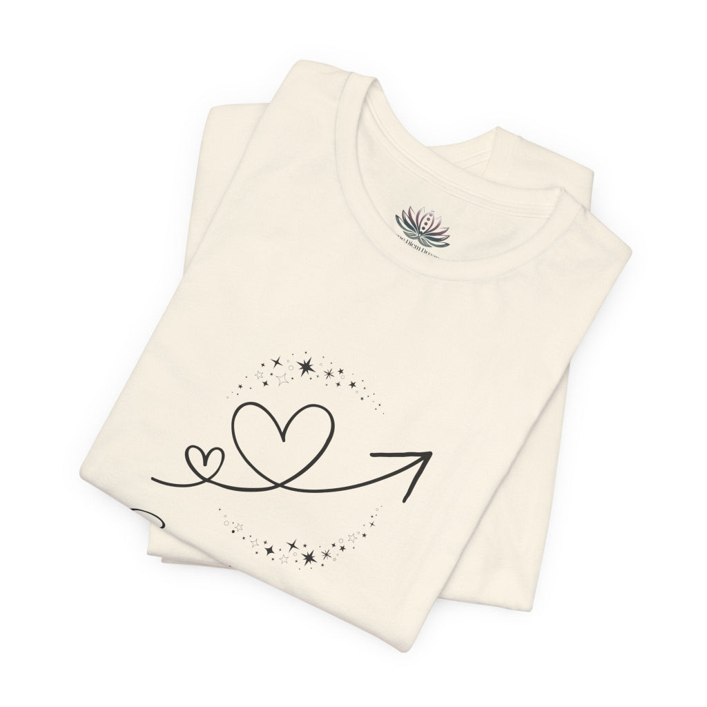 Sagittarius Rising I Explore zodiac T-shirt in Natural with black celestial heart and arrow artwork, shown folded in a supplier mockup. — for Carpe Diem Dream