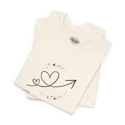 Sagittarius Rising I Explore zodiac T-shirt in Natural with black celestial heart and arrow artwork, shown folded in a supplier mockup. — for Carpe Diem Dream