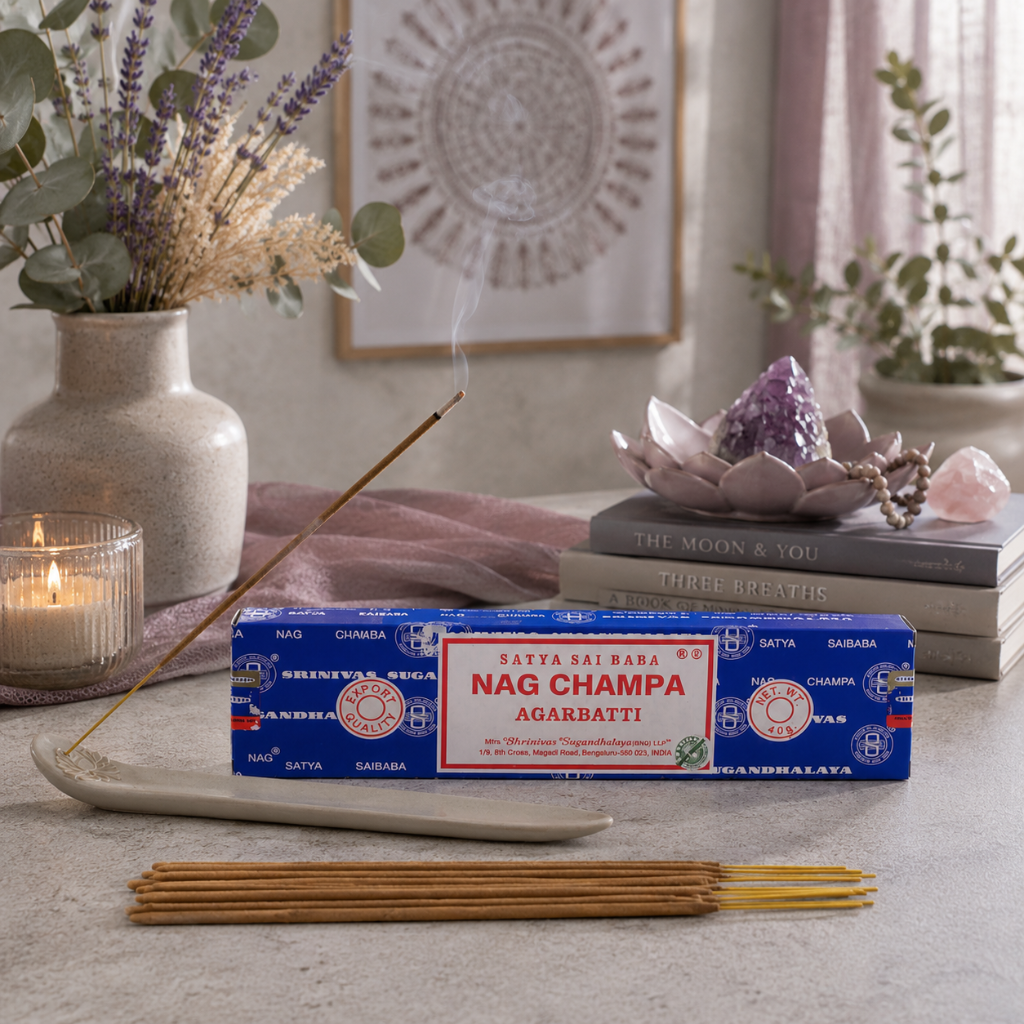 Satya Nag Champa incense styled in a cool-toned aspirational wellness space with a meditation cushion, mauve accents, botanicals, crystals, and soft natural light. — for Carpe Diem Dream.