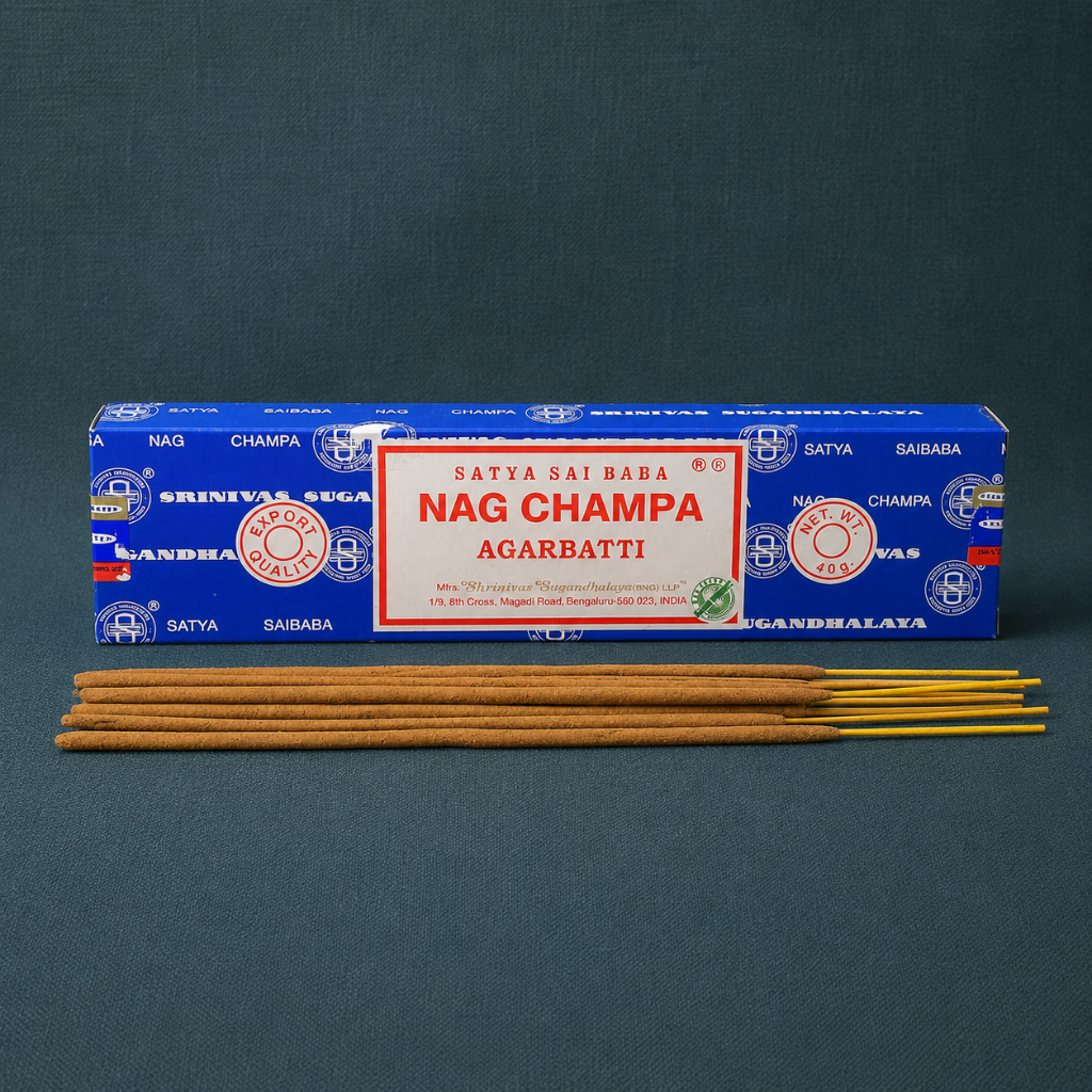 Satya Nag Champa incense box with incense sticks centered on textured dark-teal linen. — for Carpe Diem Dream.