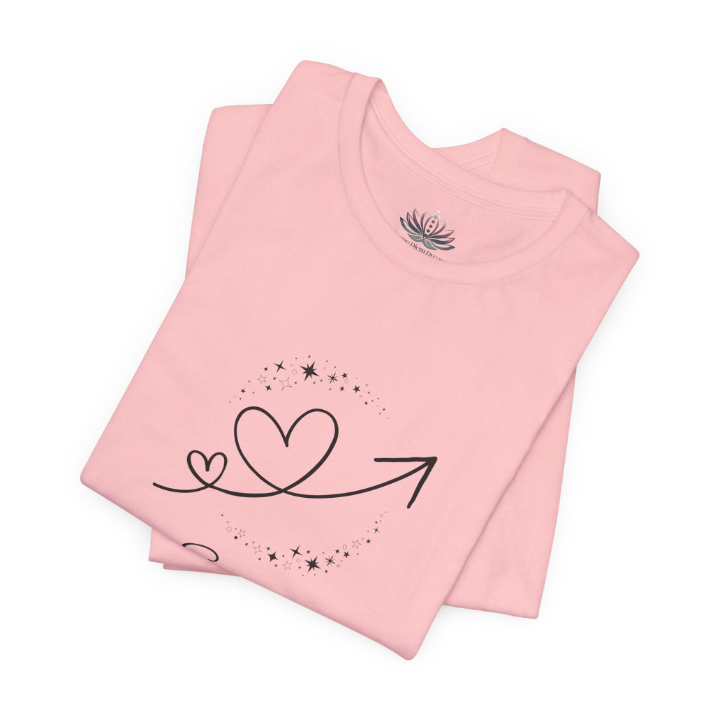 Scorpio Rising I Perceive zodiac T-shirt in pink with black celestial heart and arrow artwork, shown folded in a supplier mockup. — for Carpe Diem Dream
