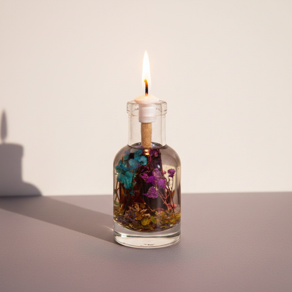 A Scorpio zodiac oil candle with deep-toned botanicals in a clear glass vessel burns with a steady flame against a soft neutral studio background. — for Carpe Diem Dream