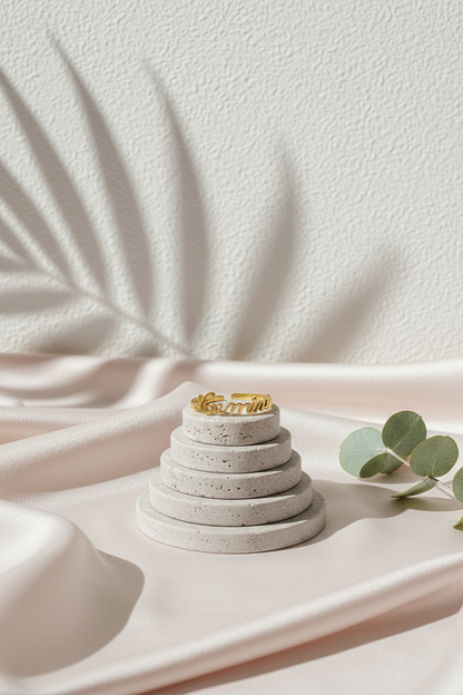 18K gold Scripted Zodiac Ring featuring delicate cursive lettering of zodiac Gemini, displayed on botanical pink silk and travertine background for Carpe Diem Dream