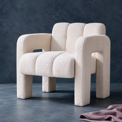 Beige sculpted bouclé upholstered accent chair professionally photographed on a cool blue-gray stone surface with a textured studio backdrop and mauve textile accent. — for Carpe Diem Dream
