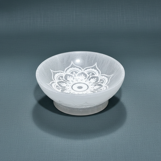 A translucent white selenite bowl engraved with a mandala lotus design displayed on a muted sage backdrop. — for Carpe Diem Dream