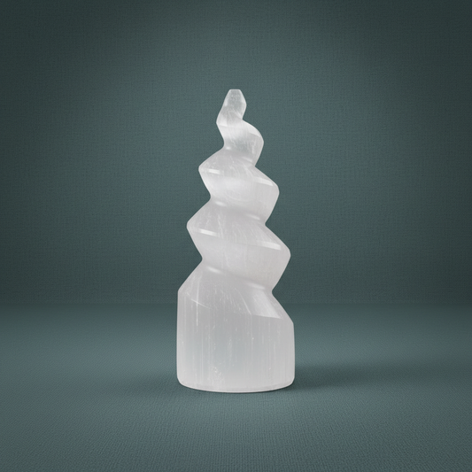 A carved selenite spiral tower standing upright against a muted teal background. — for Carpe Diem Dream