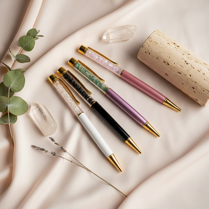 Self-cleansing crystal ballpoint pens arranged with natural stones and botanicals on soft neutral fabric in a calm mindful ritual setting. — for Carpe Diem Dream