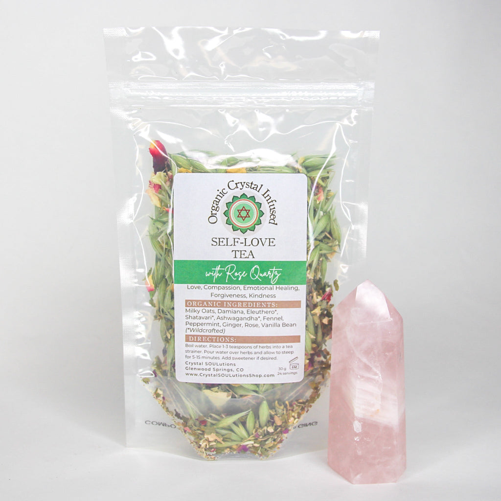 30g Self-Love Crystal Infused Tea featuring organic loose-leaf herbs and Rose Quartz crystal energy, displayed in a clear package beside a polished Rose Quartz point on a clean white background. — for Carpe Diem Dream