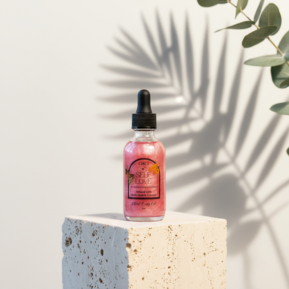 Self Love Ritual Body Oil bottle with rose quartz crystals displayed on a travertine pedestal with botanical shadows and eucalyptus leaves. — for Carpe Diem Dream