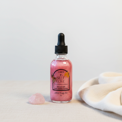 Self Love Ritual Body Oil bottle with rose quartz crystal beside it on a soft neutral fabric surface in a minimalist studio setting. — for Carpe Diem Dream