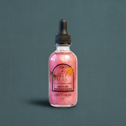 Pink Self Love Ritual Body Oil bottle with rose quartz crystals and black dropper displayed upright on a muted teal linen background. — for Carpe Diem Dream