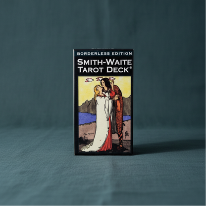 A Smith-Waite Tarot Deck borderless edition box featuring The Lovers card artwork displayed upright on a deep teal linen background with soft studio lighting. — for Carpe Diem Dream