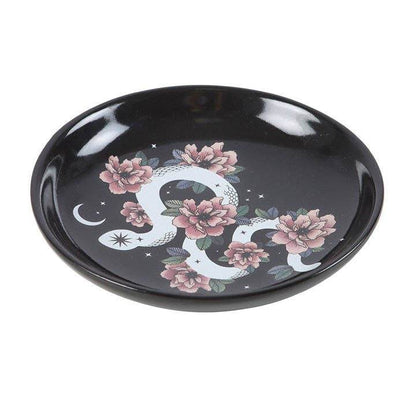Snake & Flower Celestial Trinket Dish featuring a white serpent coiled around pink flowers on a black starry background with crescent moon accents, captured in soft natural light , angle view for Carpe Diem Dream’s mystical home décor collection.