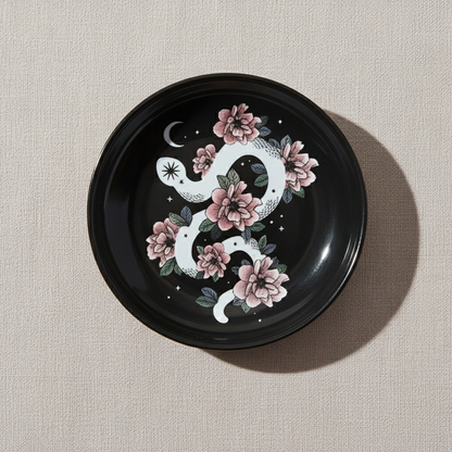 Snake & Flower Celestial Trinket Dish featuring a white serpent entwined with pink blossoms on a glossy black surface, displayed on a soft neutral background – for Carpe Diem Dream.