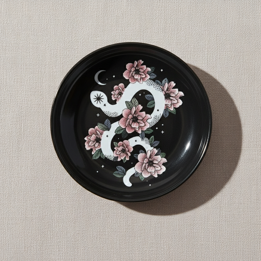 Snake & Flower Celestial Trinket Dish featuring a white serpent entwined with pink blossoms on a glossy black surface, displayed on a soft neutral background – for Carpe Diem Dream.