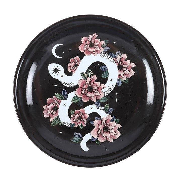 Snake & Flower Celestial Trinket Dish featuring a white serpent coiled around pink flowers on a black starry background with crescent moon accents, captured in soft natural light for Carpe Diem Dream’s mystical home décor collection.
