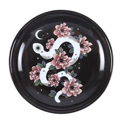 Snake & Flower Celestial Trinket Dish featuring a white serpent coiled around pink flowers on a black starry background with crescent moon accents, captured in soft natural light for Carpe Diem Dream’s mystical home décor collection.