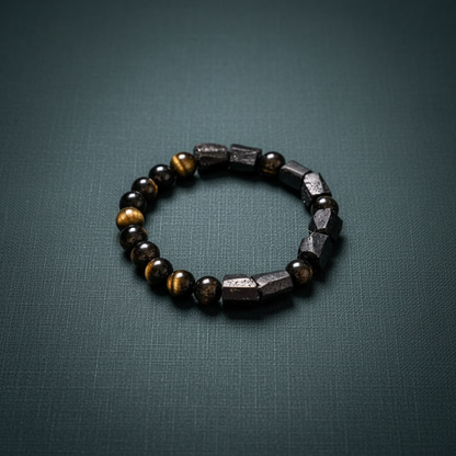 The Spiritual Protection Bracelet featuring tourmaline and golden obsidian beads arranged in a circular form on a deep teal textured background. — for Carpe Diem Dream
