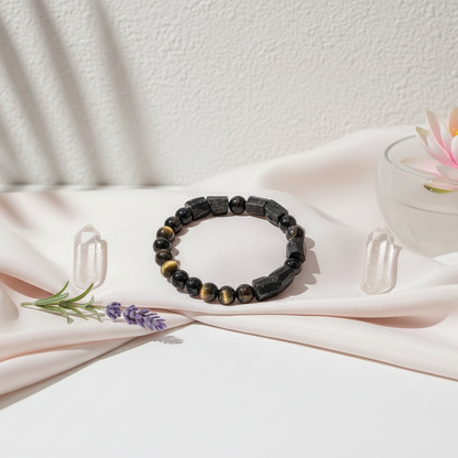 The Spiritual Protection Bracelet featuring tourmaline and golden obsidian beads styled on soft fabric with crystals and botanicals in a serene studio botanical setting. — for Carpe Diem Dream