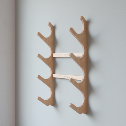 Natural wood StackRack yoga prop wall organizer mounted on a pale blue wall with soft shadows. — for Carpe Diem Dream