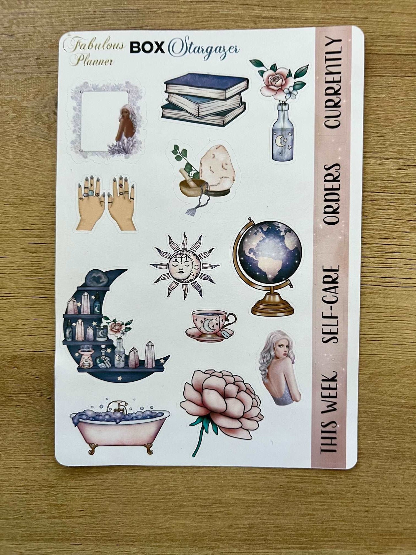 4x6 stargazer planner sticker sheet featuring mystical illustrations including books, crystals, celestial icons, self-care labels, and decorative accents on a wooden background. — for Carpe Diem Dream