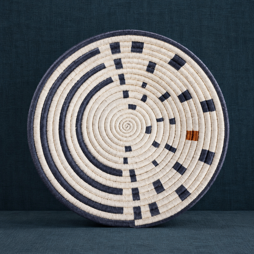 Large Sunrise Wall Basket handwoven wall basket with navy and natural spiral pattern on a dark teal textured backdrop. — for Carpe Diem Dream