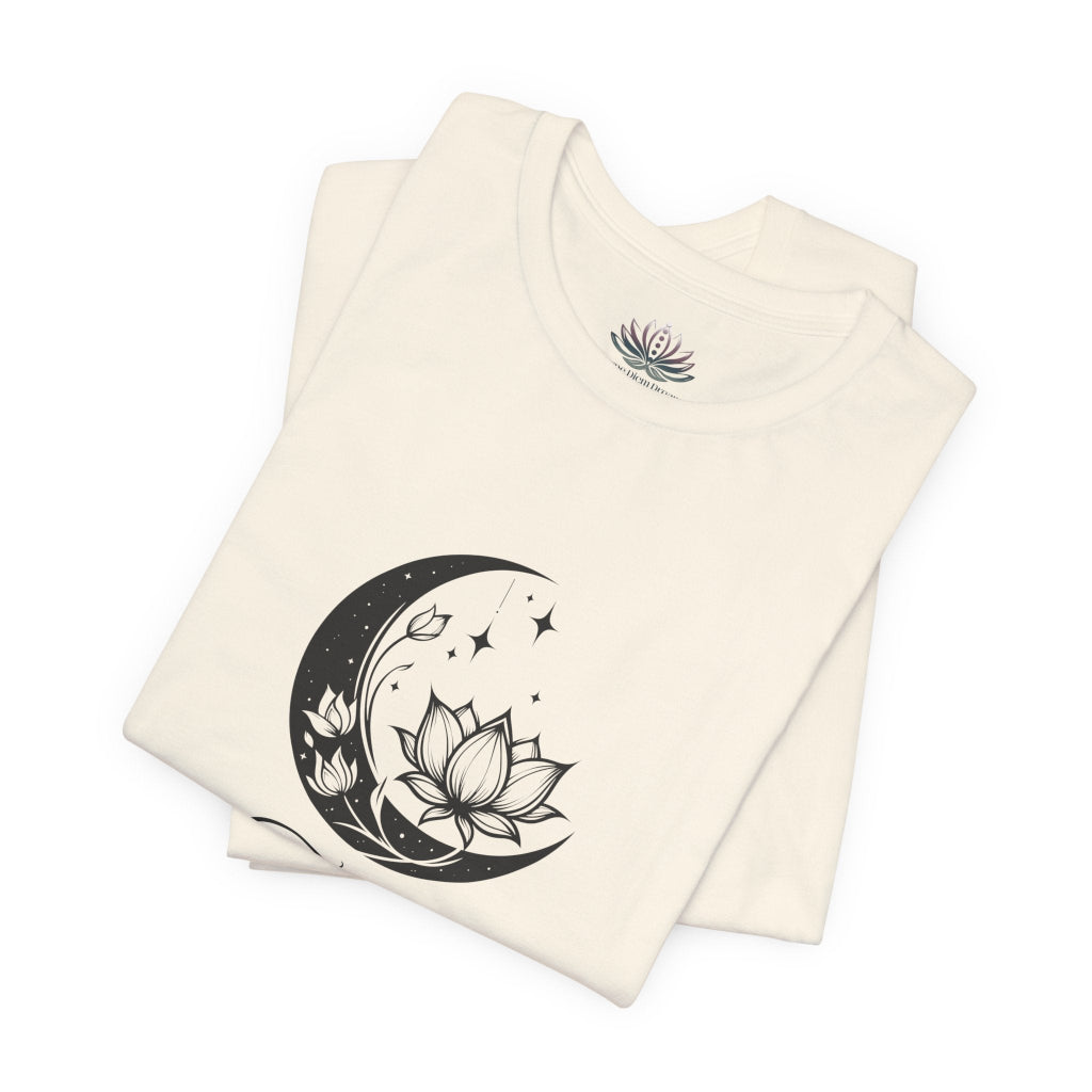 Taurus Moon I Cherish Stability zodiac T-shirt in Natural with black moon-inspired lotus, floral, and celestial artwork, shown folded in a supplier mockup. — for Carpe Diem Dream