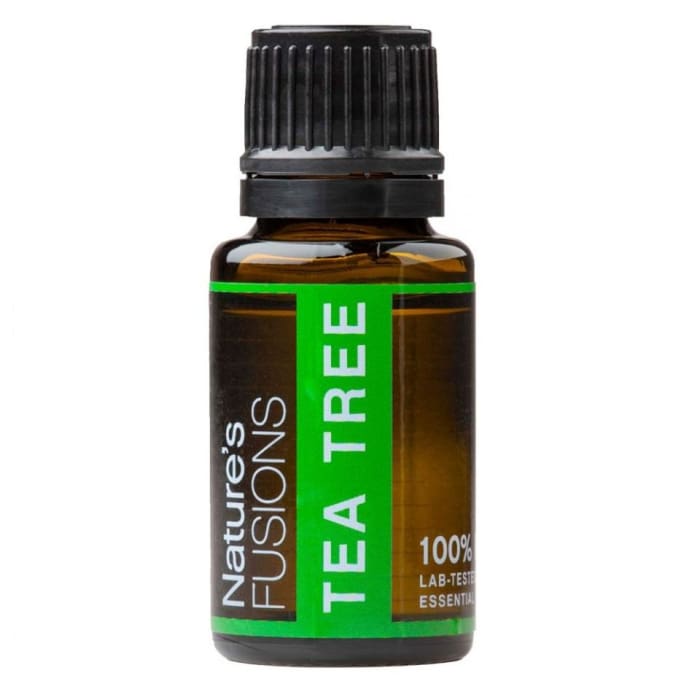 Amber glass bottle of Tea Tree Essential Oil with black ribbed cap and green label on white background. — for Carpe Diem Dream