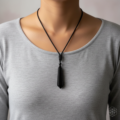 Black obsidian talisman necklace worn over a soft gray top in a clean lifestyle portrait. — for Carpe Diem Dream