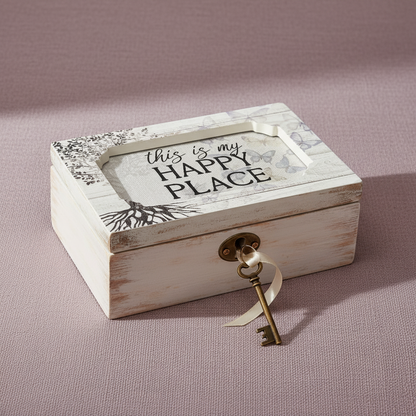 Wooden “This Is My Happy Place” music box with vintage key resting on a soft blush textured background — for Carpe Diem Dream.