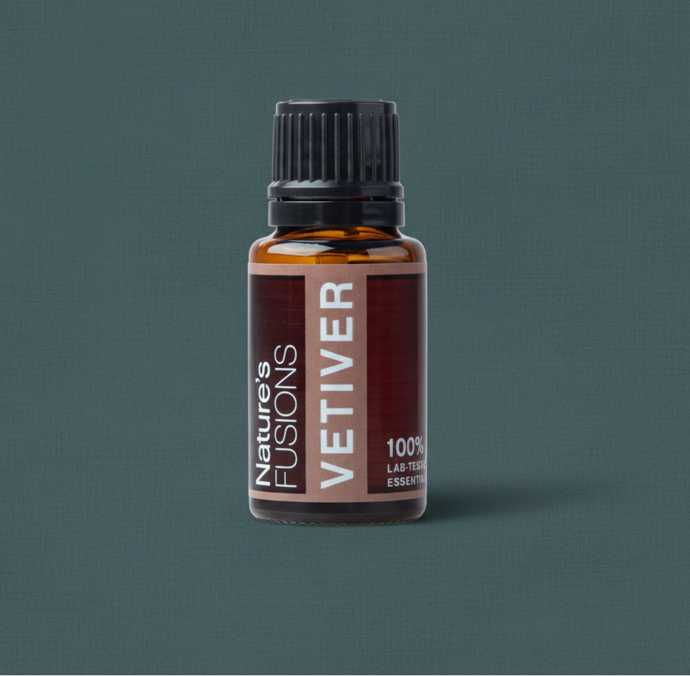 Close-up of amber glass bottle of Vetiver Essential Oil with black ribbed cap on muted teal textured background. — for Carpe Diem Dream